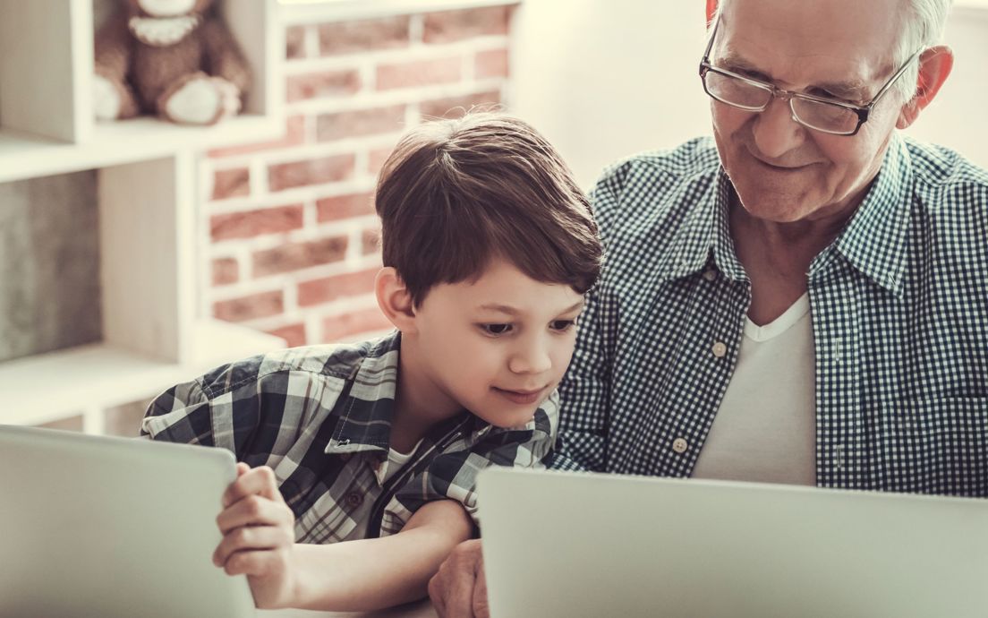 Elderly man with a young child using technology